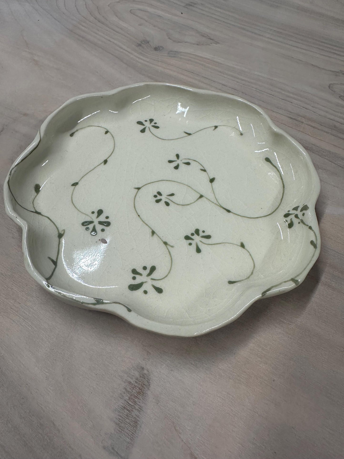 Handmade and hand painted pottery plate, scalloped edges, floral design hand painted in a sage green, finished with a clear crackle glaze