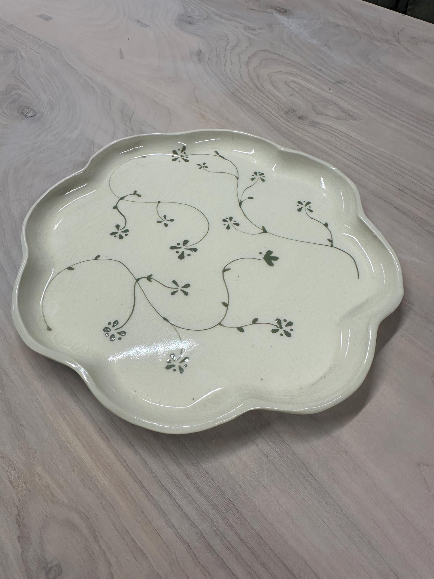 Handmade and hand painted pottery plate, scalloped edges, floral design hand painted in a sage green, finished with a clear crackle glaze